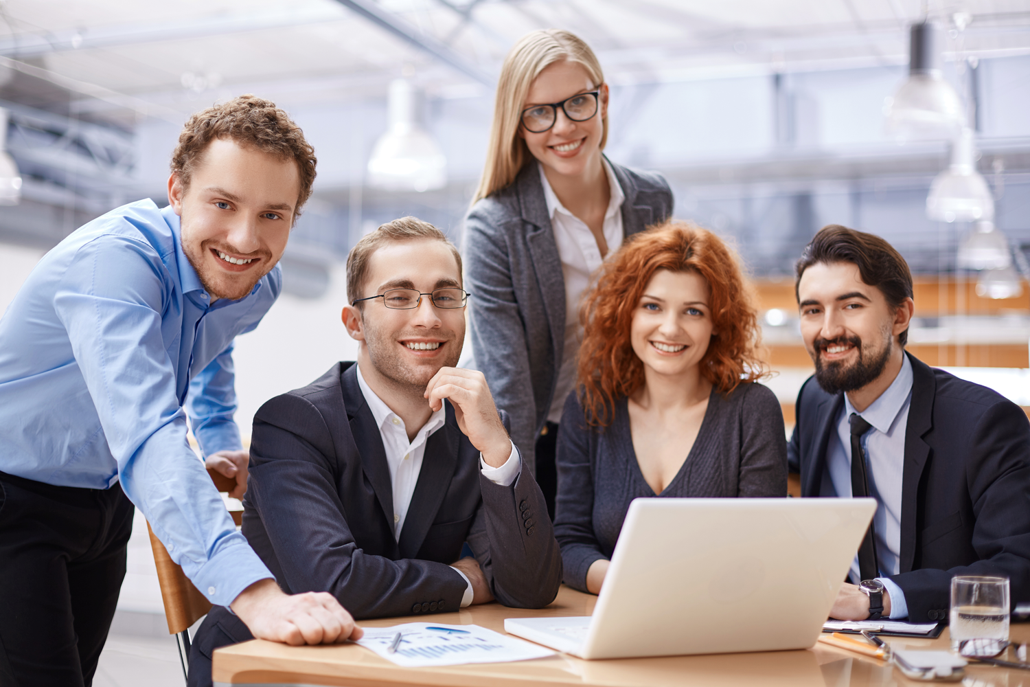 Team of young professionals smiling during a business meeting in a modern office.